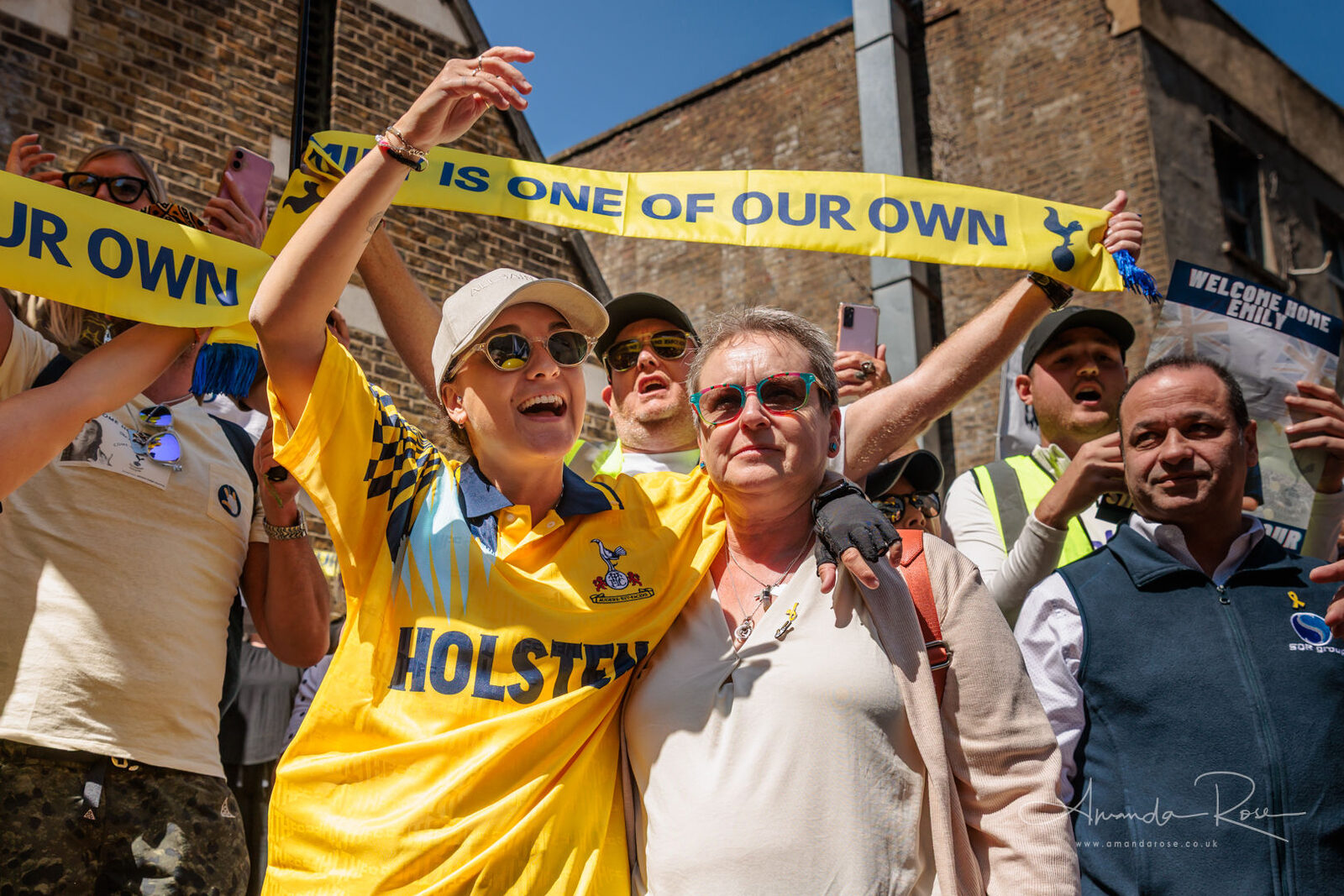 Tottenham supporters holding a scarf reading Emily is one of our own