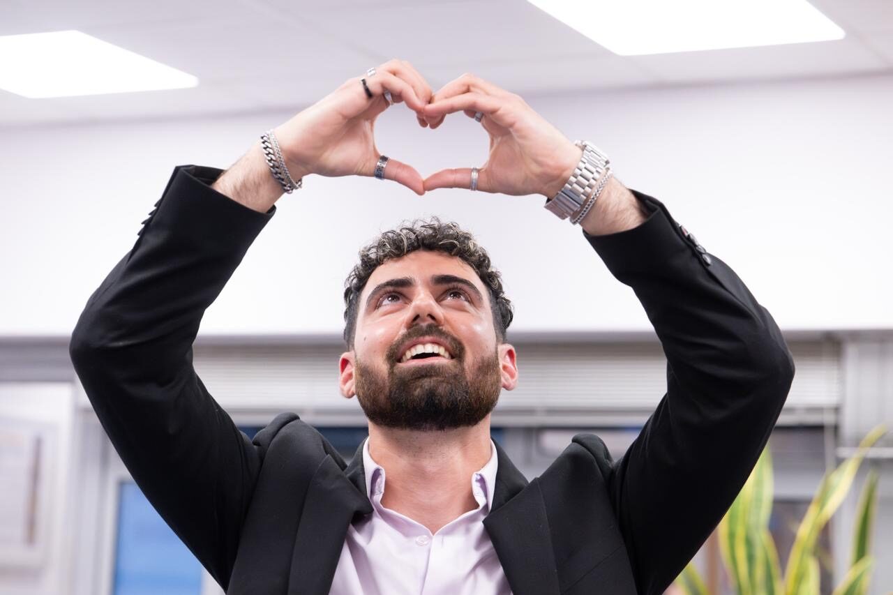 Guy Gilboa-Dalal making a heart shape with his hands