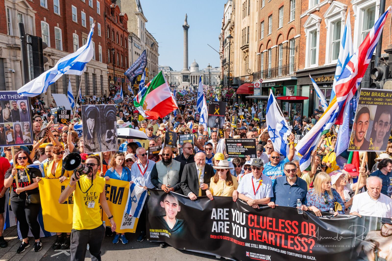 Marchers in central London carrying hostage posters and Israeli flags