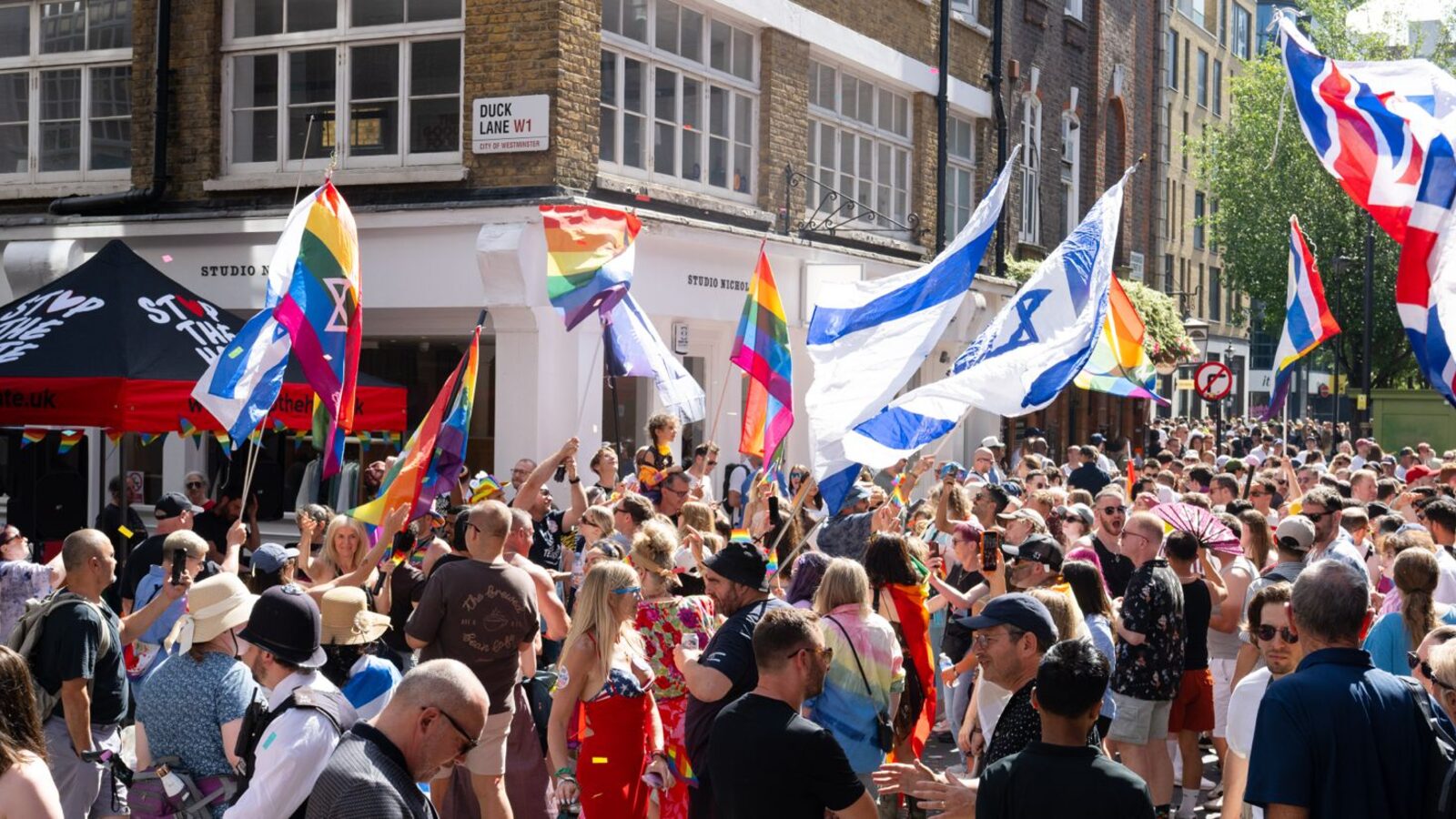 Crowds fill a Soho street with rainbow flags, Israeli flags and a Stop The Hate gazebo at Jewish Pride